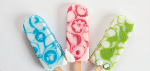 Colorful popsicles with playful patterns on white background, cheerful summer dessert treat