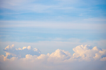 Fluffy cumulus clouds rise majestically along the horizon sky
