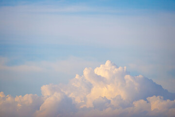Fluffy cumulus clouds rise majestically along the horizon sky