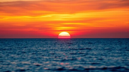 A sunset over the ocean the sky ablaze with orange red and yellow hues The suns golden orb is partially submerged below the horizon
