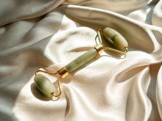 Jade stone jade roller on silk fabric for woman wellness skincare beauty natural facial massage and rejuvenating ritual