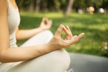 Young woman practicing yoga in the park. Concept of healthy lifestyle and relaxation.