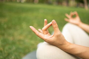 Young woman practicing yoga in the park. Concept of healthy lifestyle and relaxation.