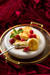 cottage cheese pancakes with raspberries on red velvet