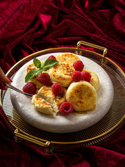 cottage cheese pancakes with raspberries on red velvet