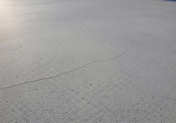 Cracked textured white surface under sunlight