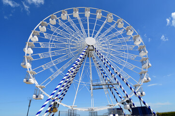  Big Wheel against blue sky with clouds.