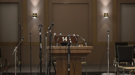 Press Conference Setup with Microphones, Podium, and Chairs in a Formal Environment
