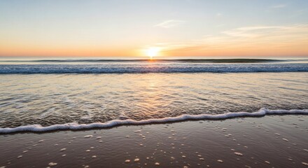 Obraz premium Sunrise over the ocean with waves lapping the shore