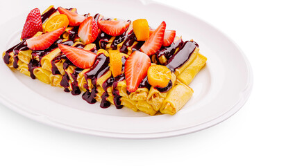 Delicious crepes topped with fresh fruit and chocolate sauce