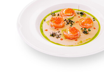 Salmon appetizers presented on a stylish white plate with vibrant garnishes