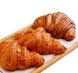 Freshly baked croissants on a wooden tray in a cozy bakery setting