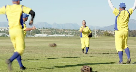 Reacting to fly ball, diverse male teammates catching with glove and celebrating catch on field - Powered by Adobe