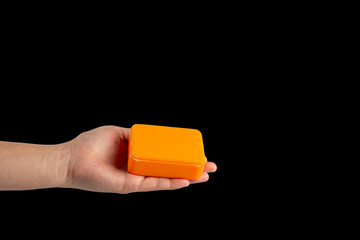 Orange soap in hand on black background