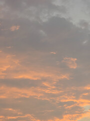 Dramatic cloudy sky during sunset with warm orange and gray tones