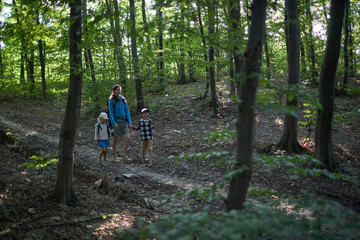 Obraz premium Mother and children hiking in the forest