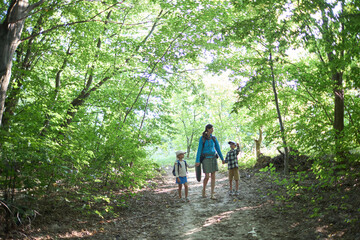 Obraz premium Mother and children hiking in the forest