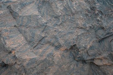  A detailed close-up of a rugged, weathered rock face revealing complex textures and intricate patterns.