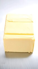 A block of butter on a metallic surface.
