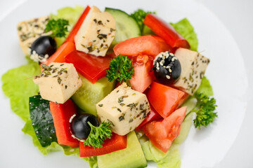 Greek salad with olives in a white plate macro photo