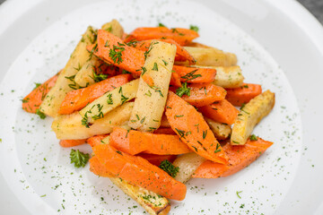 fried potatoes with carrots in spices on a white plate