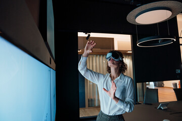 Businesswoman using VR headset in modern meeting room