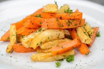 fried potatoes with carrots in spices on a white plate macro
