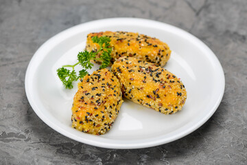 Vegetarian cutlets in a white plate on a gray concrete background