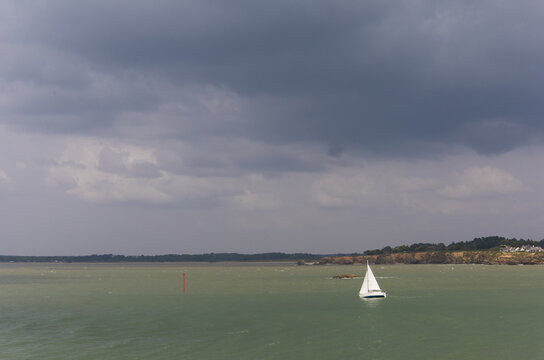 voilier blanc sous une m&eacute;t&eacute;o de temp&ecirc;te sur l'oc&eacute;an atlantique au large de la pointe de Merquel &agrave; Mesquer en Loire Atlantique en France