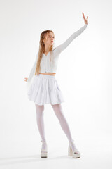 Fototapeta premium Dancer performs expressive movements in a white outfit against a minimalistic backdrop