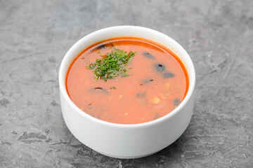 Kharcho soup in a white plate on a gray concrete background