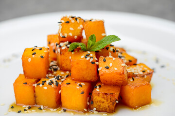 baked pumpkin with sesame seeds in a white plate
