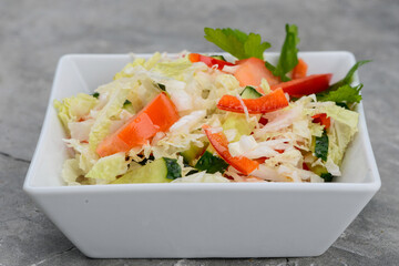 salad with cabbage, paprika and herbs in a white plate