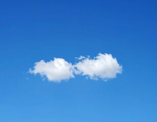 Two small, fluffy clouds against a deep blue sky