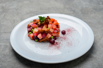 beet salad vinaigrette in a white plate on a gray background