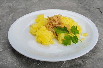 mashed potatoes with fried onions in a white plate on a gray background