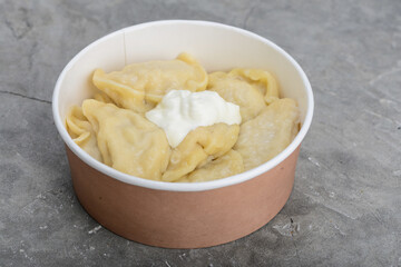 dumplings with cabbage and sour cream in disposable dishes