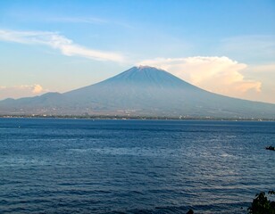 Volcanic mountain rises above the tranquil sea