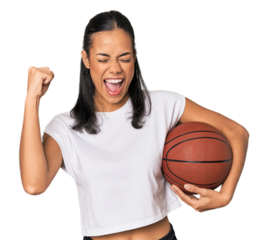 Young Filipino woman with basketball raising fist after a victory, winner concept.