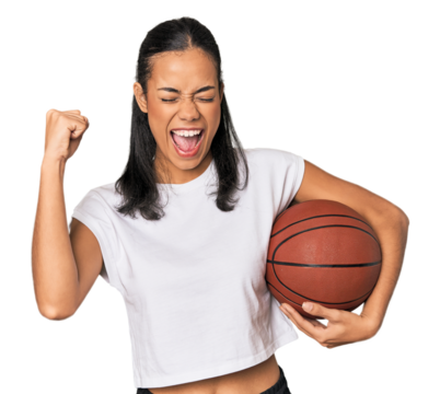 Young Filipino woman with basketball raising fist after a victory, winner concept.