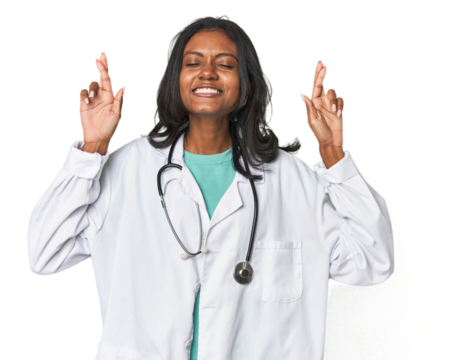 Young Indian doctor with stethoscope crossing fingers for having luck