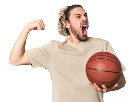 Casual young basketball player in studio raising fist after a victory, winner concept.