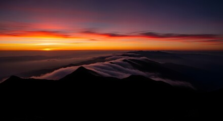 Red sunrise illuminates mountain ridges veiled in soft clouds. Creates atmosphere for landscape posters, scenic calendars, travel branding.