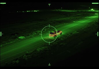Thermal night vision view of car on remote road. Military drone target system. Modern armed forces operation. Aerial surveillance.