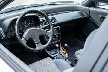 Interior view of a beautifully restored JDM classic compact sports car, showcasing the clean cockpit, dashboard, steering wheel, and custom shift knob