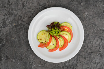 zucchini salad with tomatoes and cheese in a white plate photo