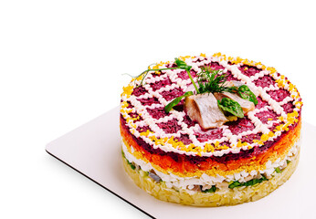 Colorful layered salad presented on a white plate with fresh garnishes