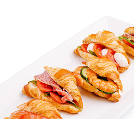 Delicious savory croissant sandwiches with fresh fillings on a platter