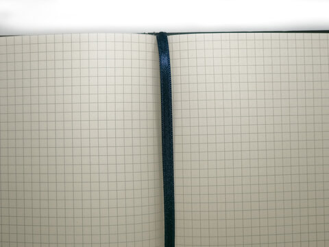 Open squared notebook with empty grid pages and dark bookmark