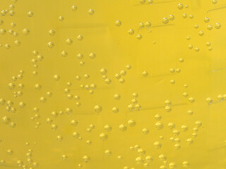 Close up of carbonated yellow liquid with rising bubbles